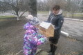 Анна Петровна помогает ученикам повесить кормушки.